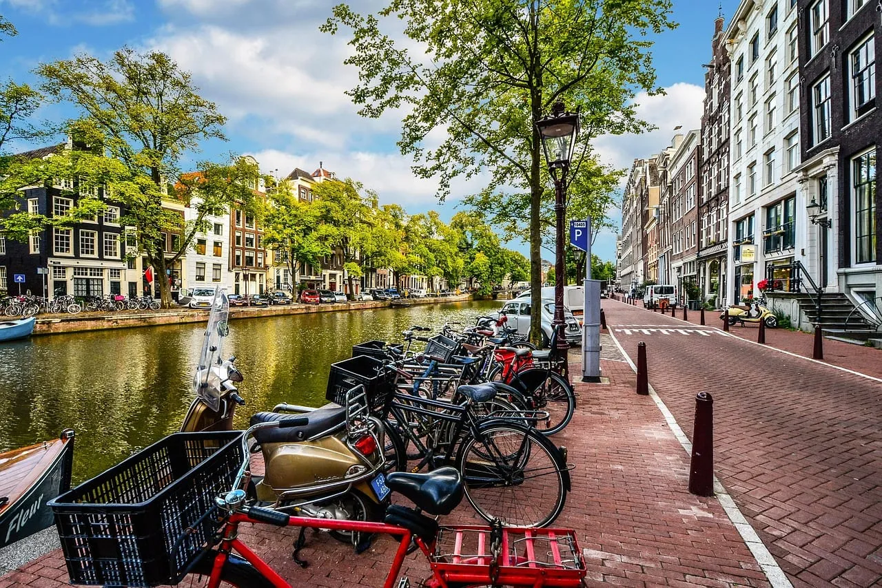 Abgestellte Fahrräder an einer Gracht bei Sonnenschein
