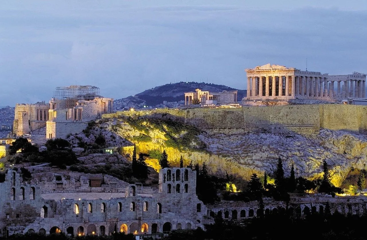 Die angestrahlte Akropolis in der Abenddämmerung, darunter das Odeon des Herodes Atticus
