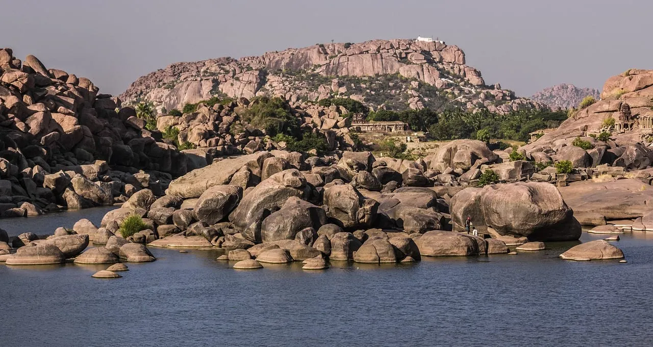 Mit Felsblöcken übersäte Hügel über dem Fluss bei Hampi