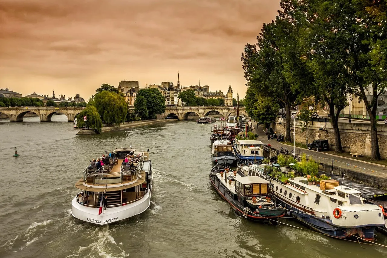 Ein Ausflugsboot und Hausboote auf der Seine unterhalb der Île de la Cité