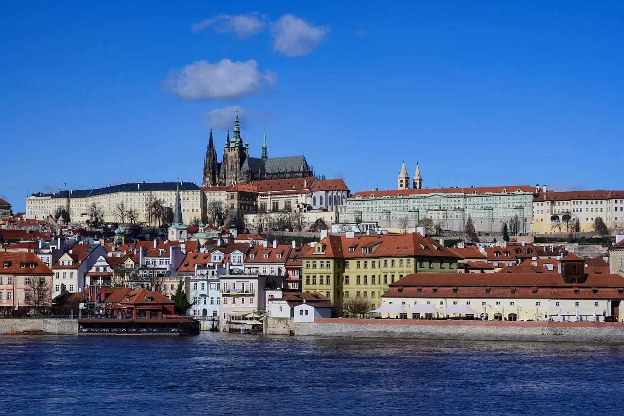 Die Burganlage am anderen Moldauufer unter blauem Himmel