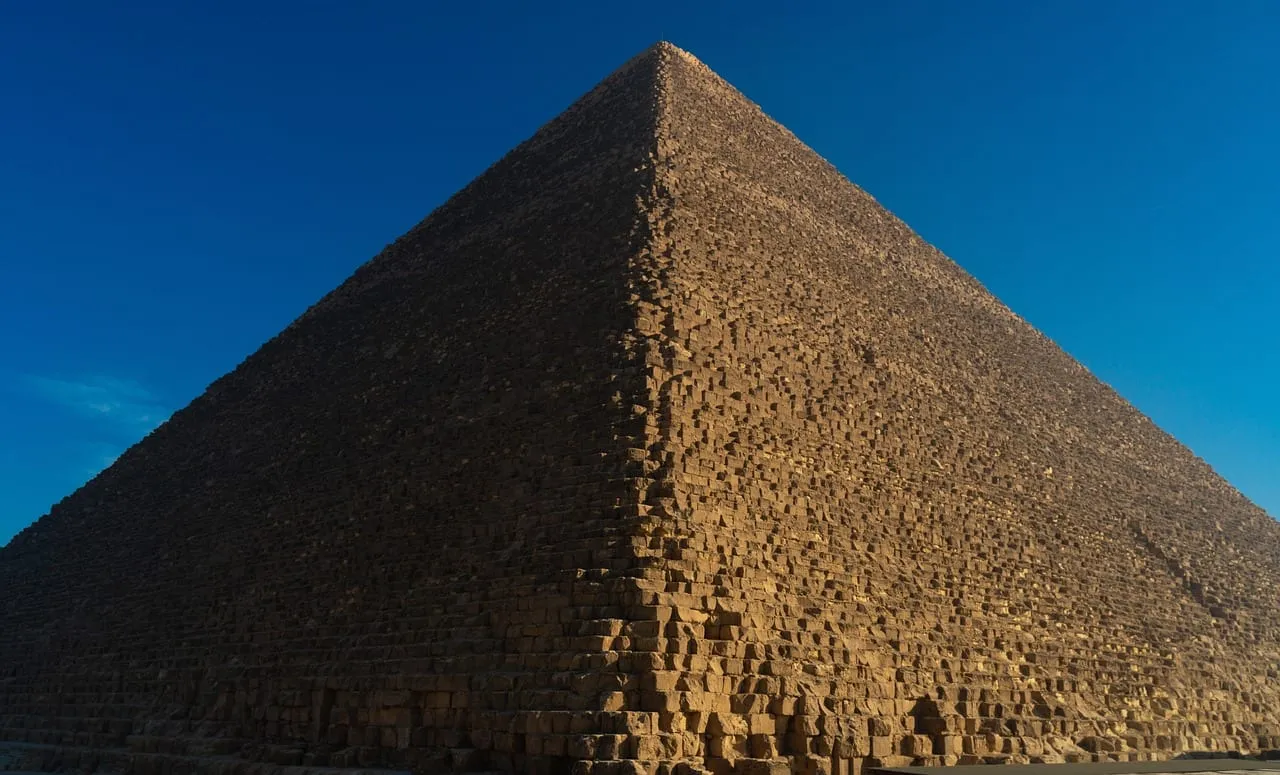 Die gestufte Steinwand einer Pyramide vor tiefblauem Himmel