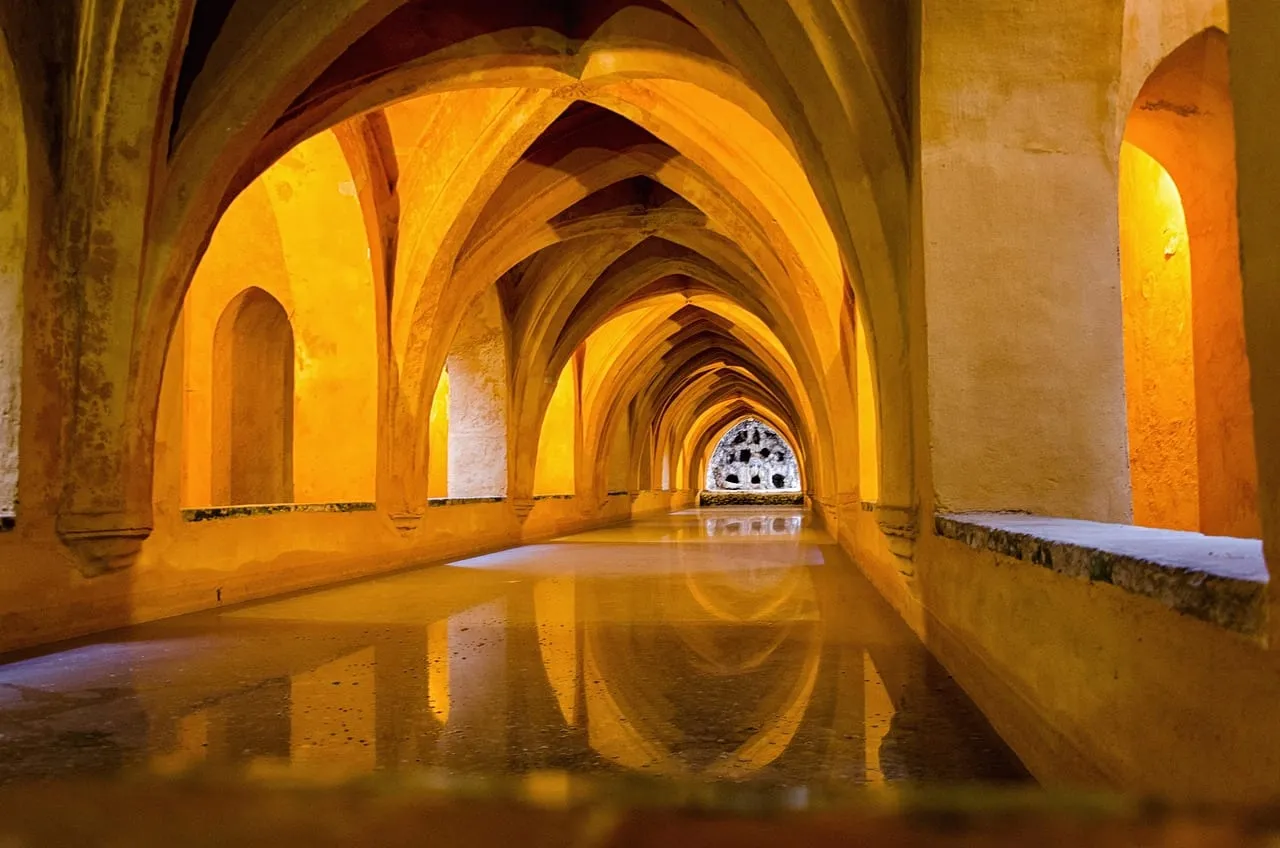 Ein überwölbtes unterirdisches Becken in warmem, orangefarbenem Licht