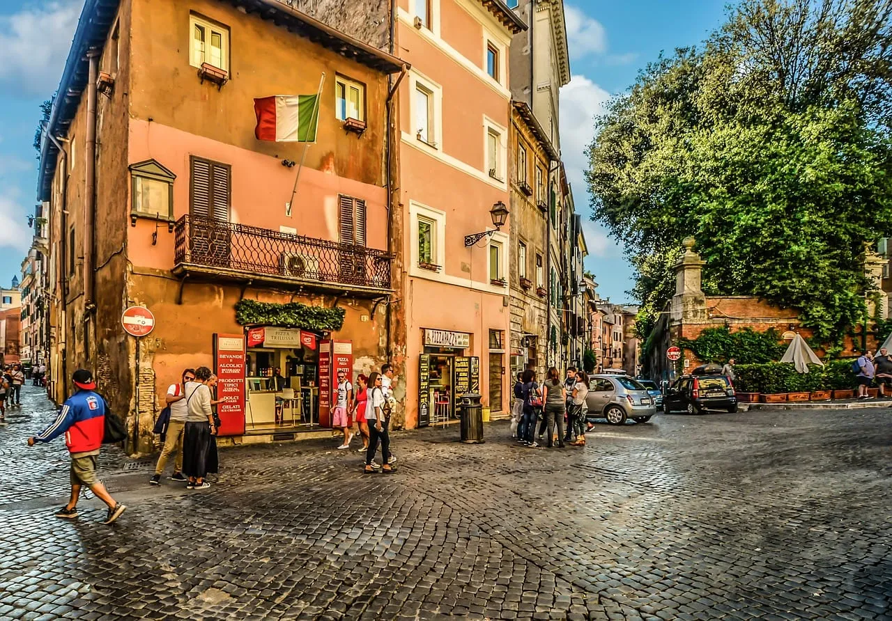 Eine Straßenecke in Trastevere mit ockerfarbenen Häusern und einem Café